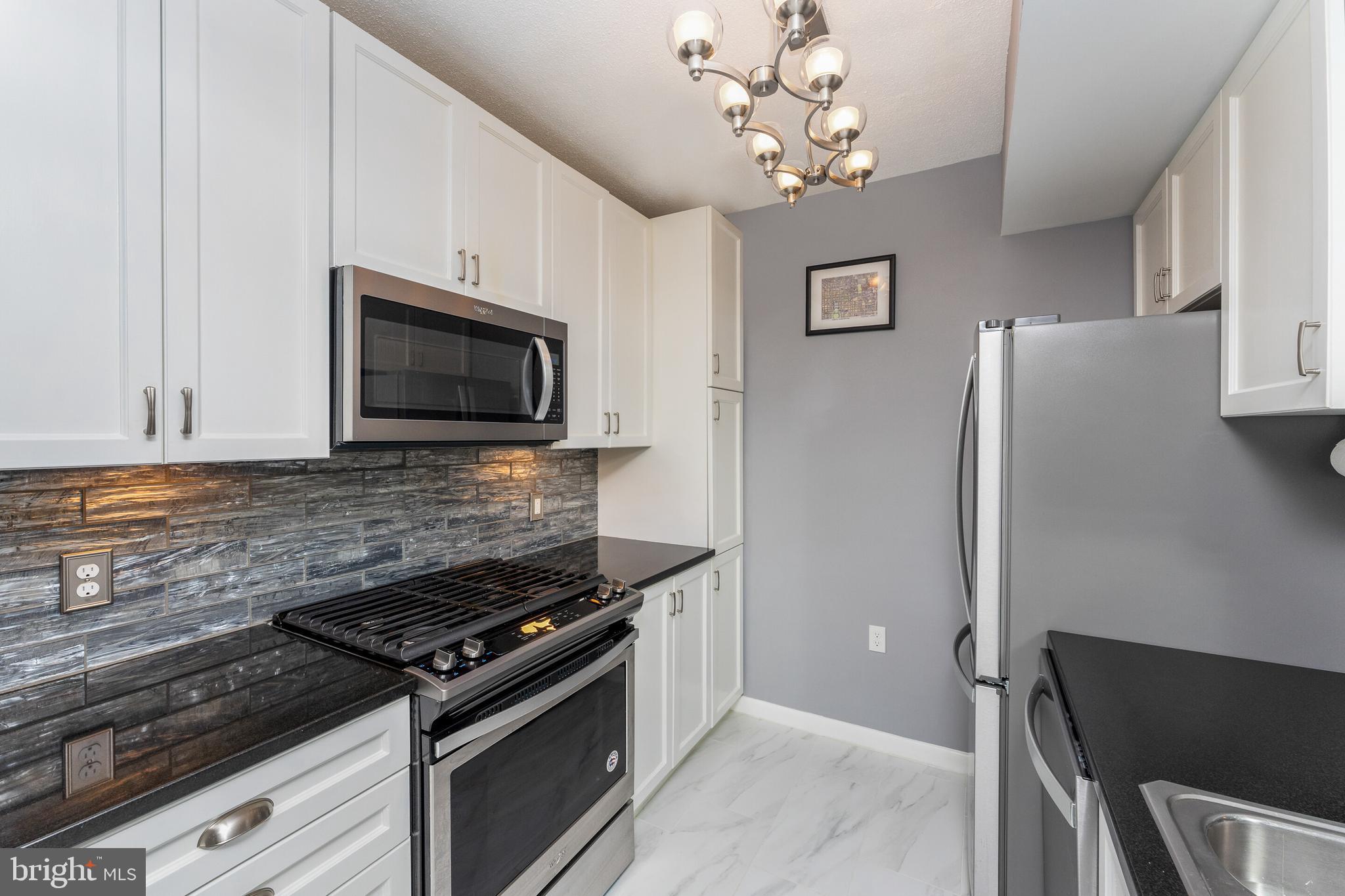 851 North Glebe Road, Unit 1818 Arlington, VA 22203 - Photo 5 of 23 a kitchen with stainless steel appliances granite countertop a refrigerator and a stove top oven