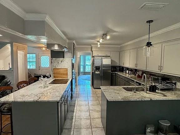9911 Silver Creek Road Dallas, TX 75243 - Photo 7 of 28 Spacious kitchen featuring an island, peninsula, stainless steel appliances, and tile flooring