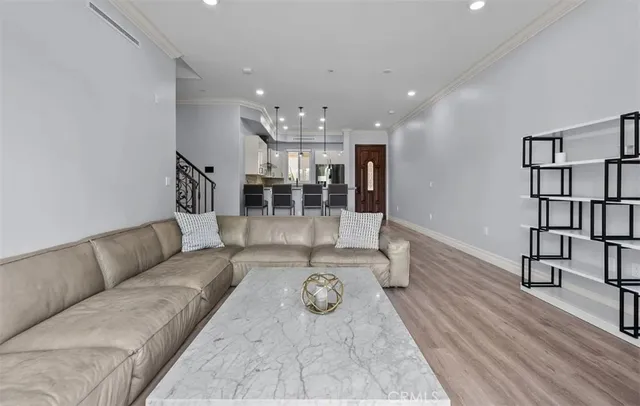 a living room with furniture and view of kitchen