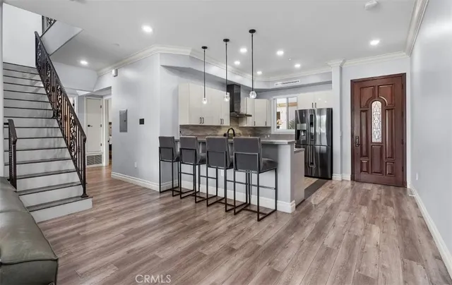 a view of kitchen with stainless steel appliances refrigerator stove microwave and wooden floor