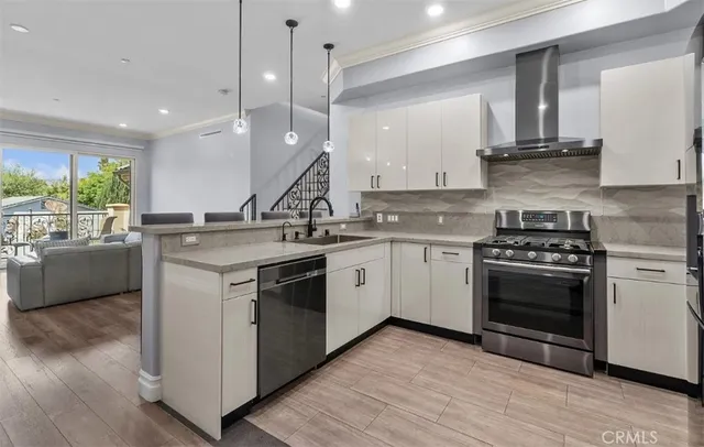 a kitchen with a stove a sink and a wooden floor