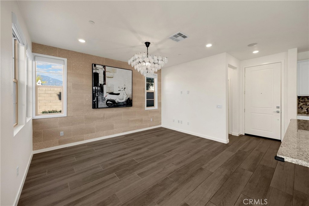 2323 Apple Upland, CA 91786 - Photo 12 of 57 an empty room with wooden floor chandelier and windows