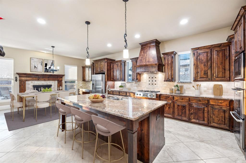 6579 Mountain Sky Road Frisco, TX 75036 - Photo 13 of 40 a large kitchen with granite countertop a island in the center and stainless steel appliances
