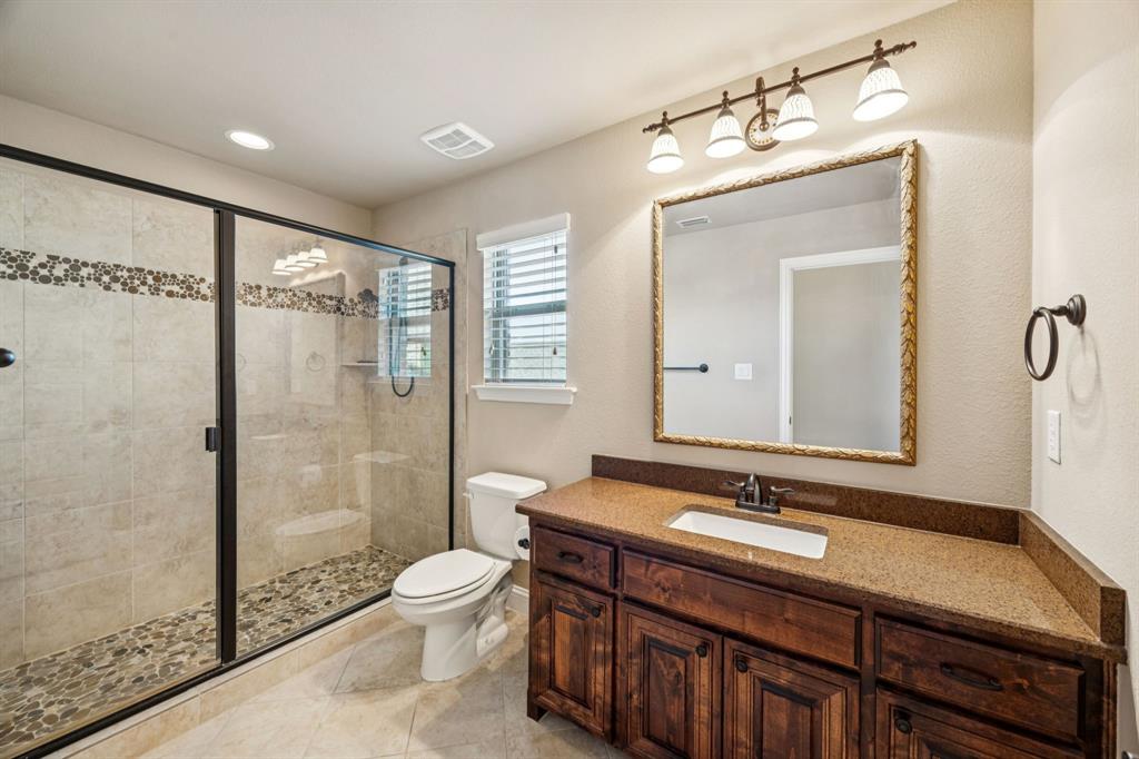 6579 Mountain Sky Road Frisco, TX 75036 - Photo 24 of 40 a bathroom with a double vanity sink toilet mirror and shower