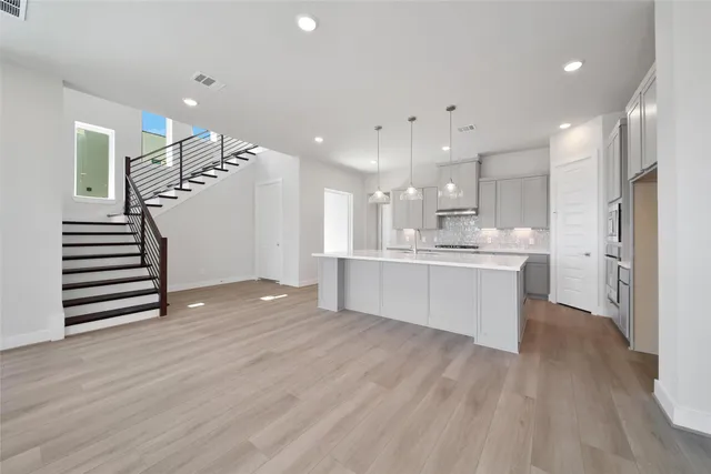 a view of kitchen with cabinets stainless steel appliances and wooden floor