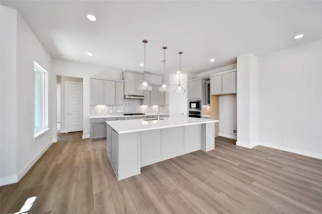 a large kitchen with a lot of counter space and wooden floor