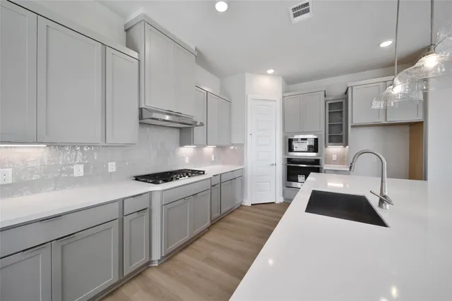 a kitchen with kitchen island granite countertop a sink stainless steel appliances and cabinets