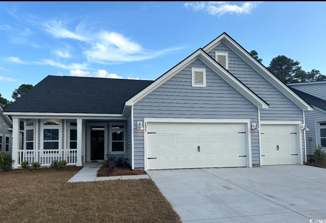 6053 Zoe Way Myrtle Beach, SC 29588 - Photo 1 of 27 Ranch-style house featuring concrete driveway, roof with shingles, a front lawn, a garage, and a porch