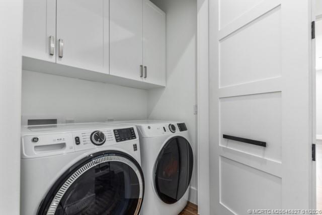 53 Southeast Seminole Street, Unit 2B Stuart, FL 34994 - Photo 28 of 31 a view of washer and dryer with kitchen in the background