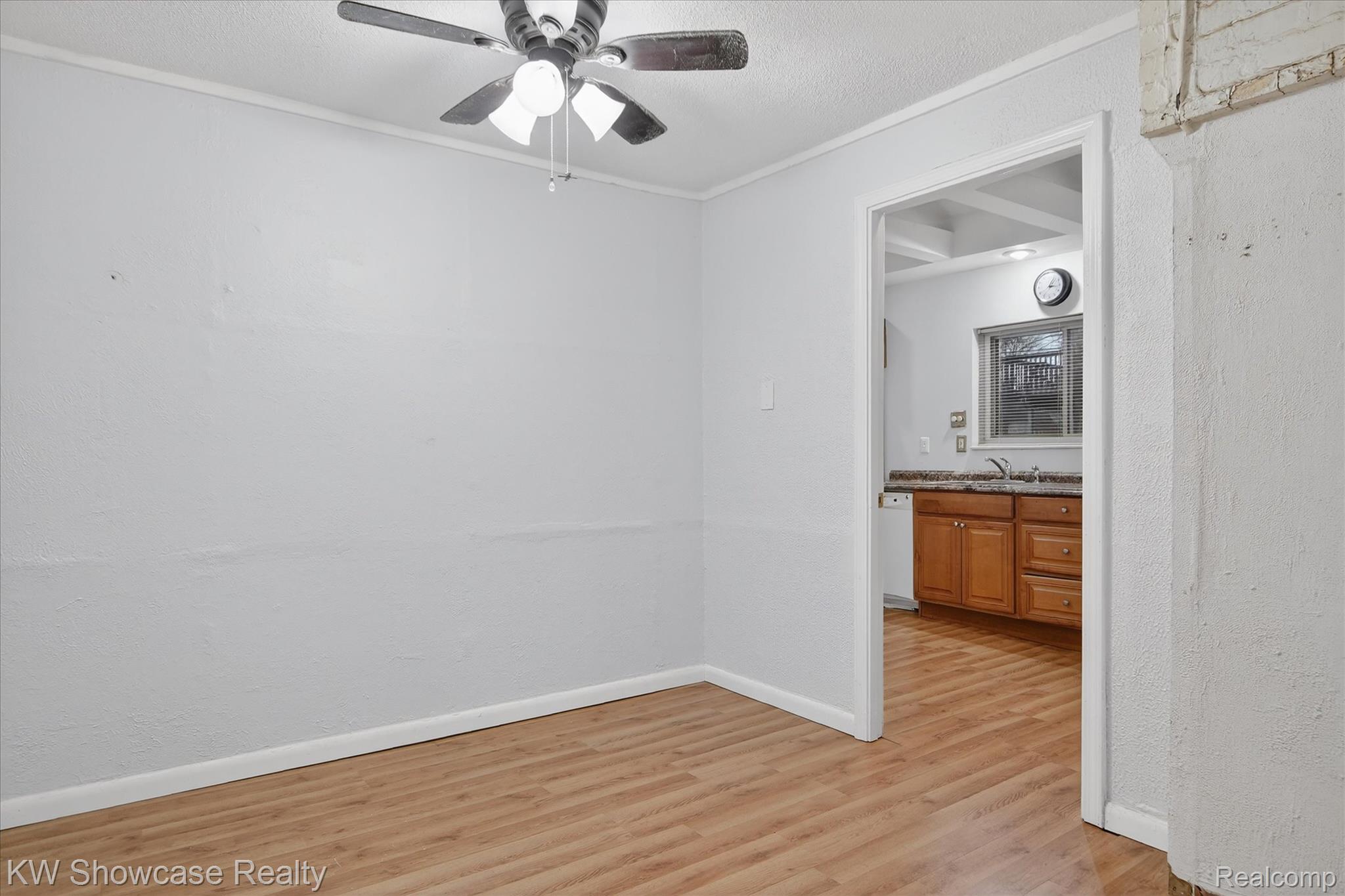 1860 Ladd Road Walled Lake, MI 48390 - Photo 22 of 48 Empty room with light wood-style floors, a ceiling fan, a textured ceiling, and ornamental molding