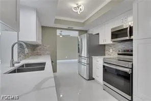 a kitchen with stainless steel appliances granite countertop a sink and a refrigerator