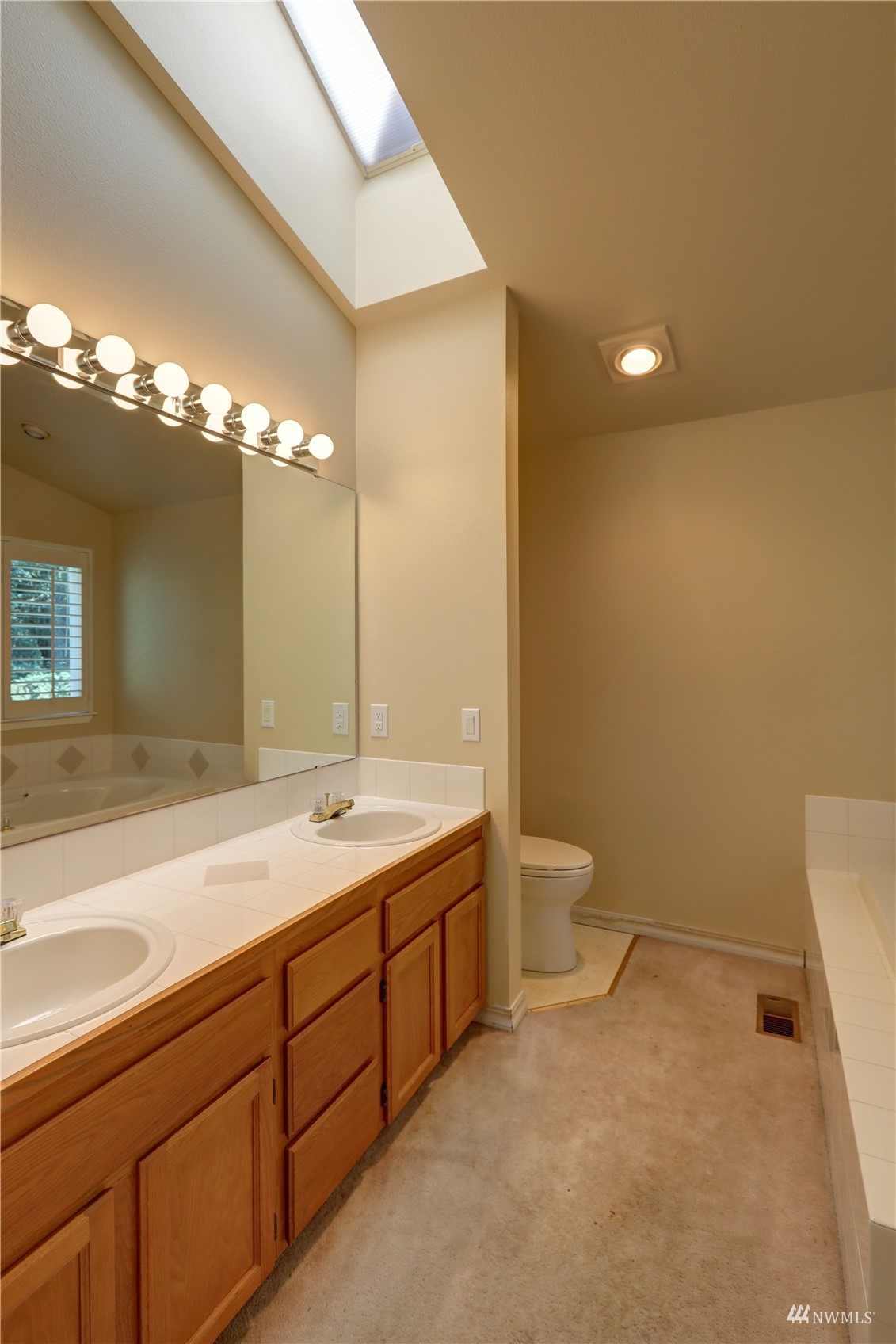 1635 Field Place Northeast Renton, WA 98059 - Photo 20 of 28 a bathroom with a granite countertop sink a toilet and a large mirror