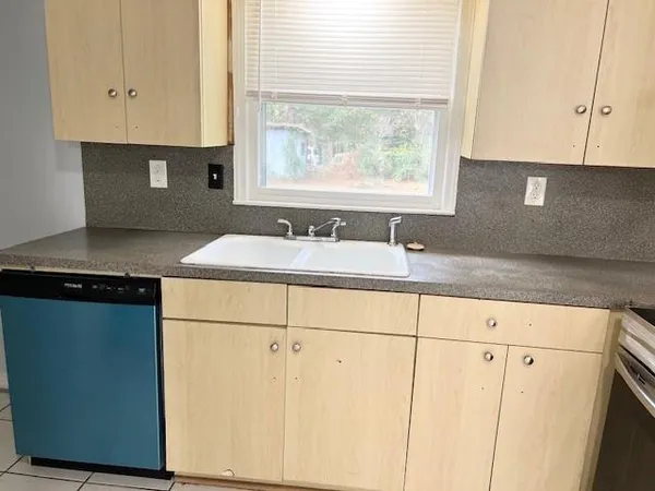 a kitchen with granite countertop a sink cabinets and window