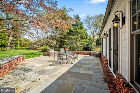 a view of a patio with table and chairs and floor to ceiling window and wooden fence
