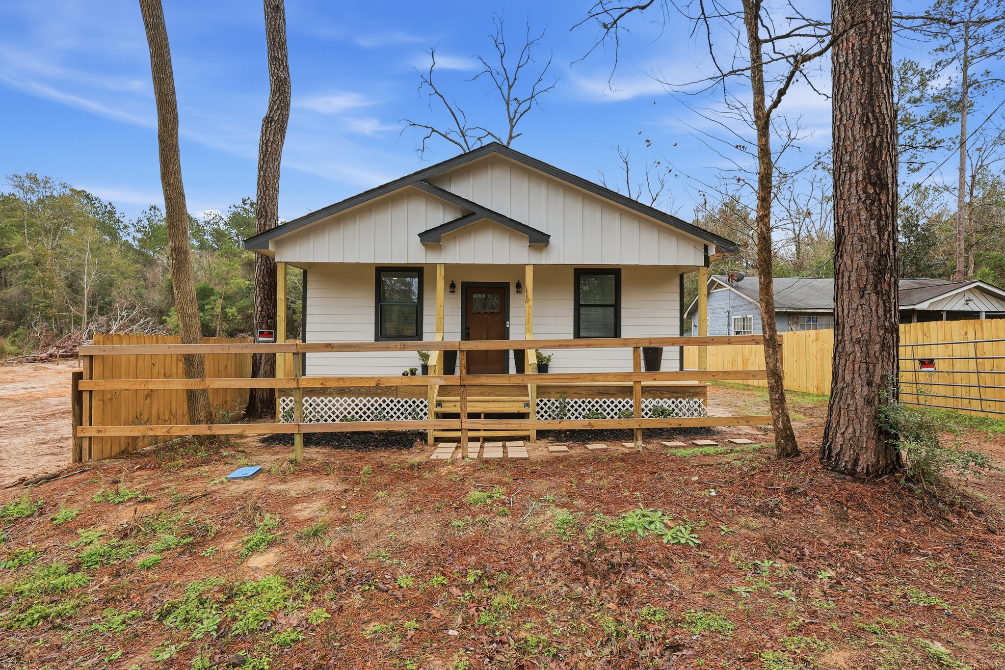 a view of a house with a yard and wooden fence