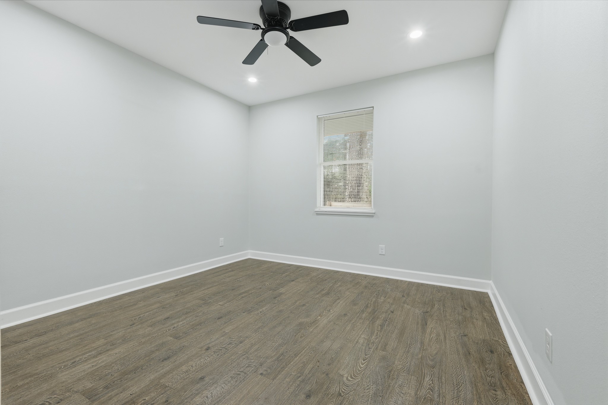 160 Oak Lane Shepherd, TX 77371 - Photo 11 of 15 an empty room with wooden floor ceiling fan and windows