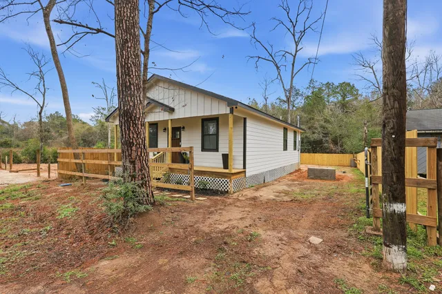 a view of a house with backyard and a tree