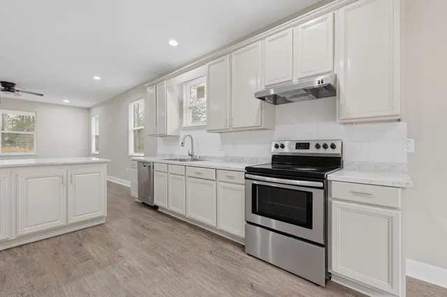a kitchen with white cabinets stainless steel appliances and sink
