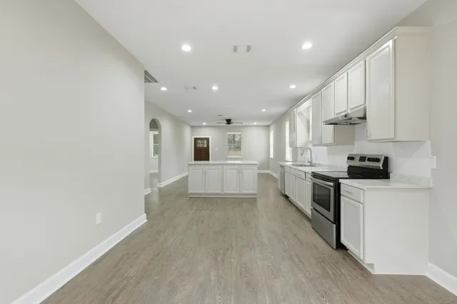 a view of kitchen with sink and refrigerator