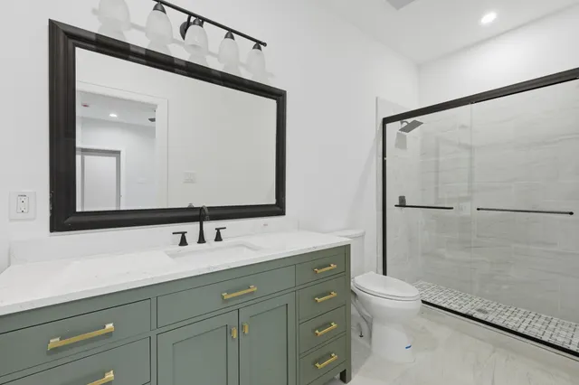 a bathroom with a double vanity sink mirror and toilet