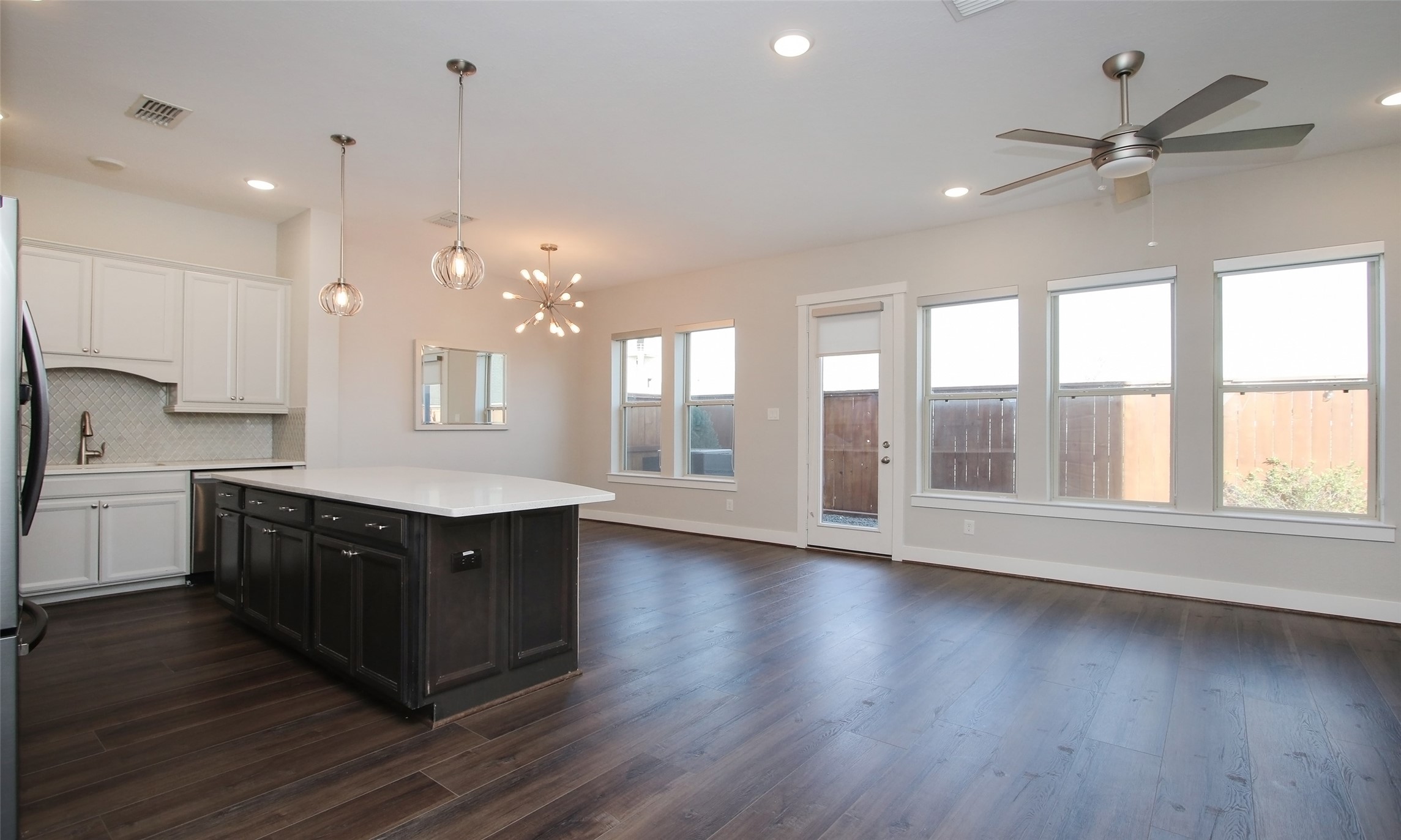 12502 Malachite Way Houston, TX 77077 - Photo 7 of 41 First floor living with a large island kitchen and access to the dining room, living room and outdoor patio/garden