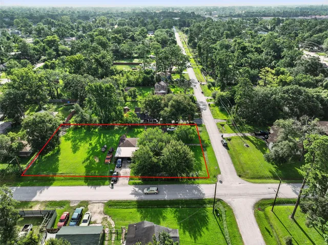 an aerial view of residential houses with outdoor space and trees