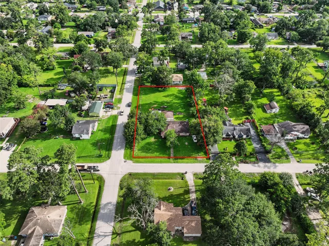 an aerial view of residential house with outdoor space and trees all around