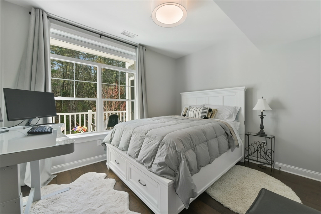 635 Old Post Road, Unit 2209 Sharon, MA 02067 - Photo 23 of 42 a bedroom with a bed and a desk