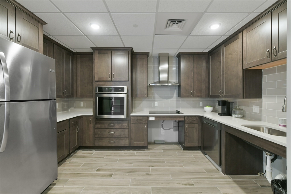 635 Old Post Road, Unit 2209 Sharon, MA 02067 - Photo 32 of 42 a large kitchen with stainless steel appliances granite countertop a refrigerator and a stove top oven