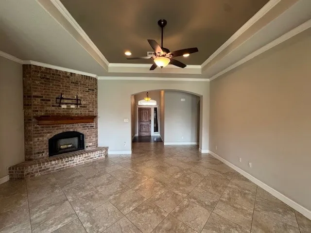 a view of a livingroom with a fireplace a chandelier and windows