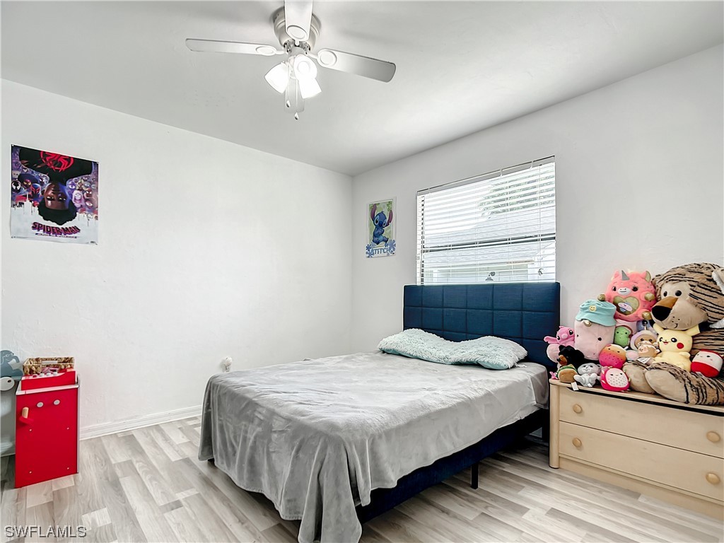 2437 42nd Terrace Southwest Naples, FL 34116 - Photo 17 of 34 a bedroom with a bed and a chandelier