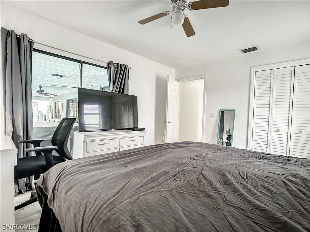2437 42nd Terrace Southwest Naples, FL 34116 - Photo 18 of 34 a bedroom with a bed a mirror on dresser and a window