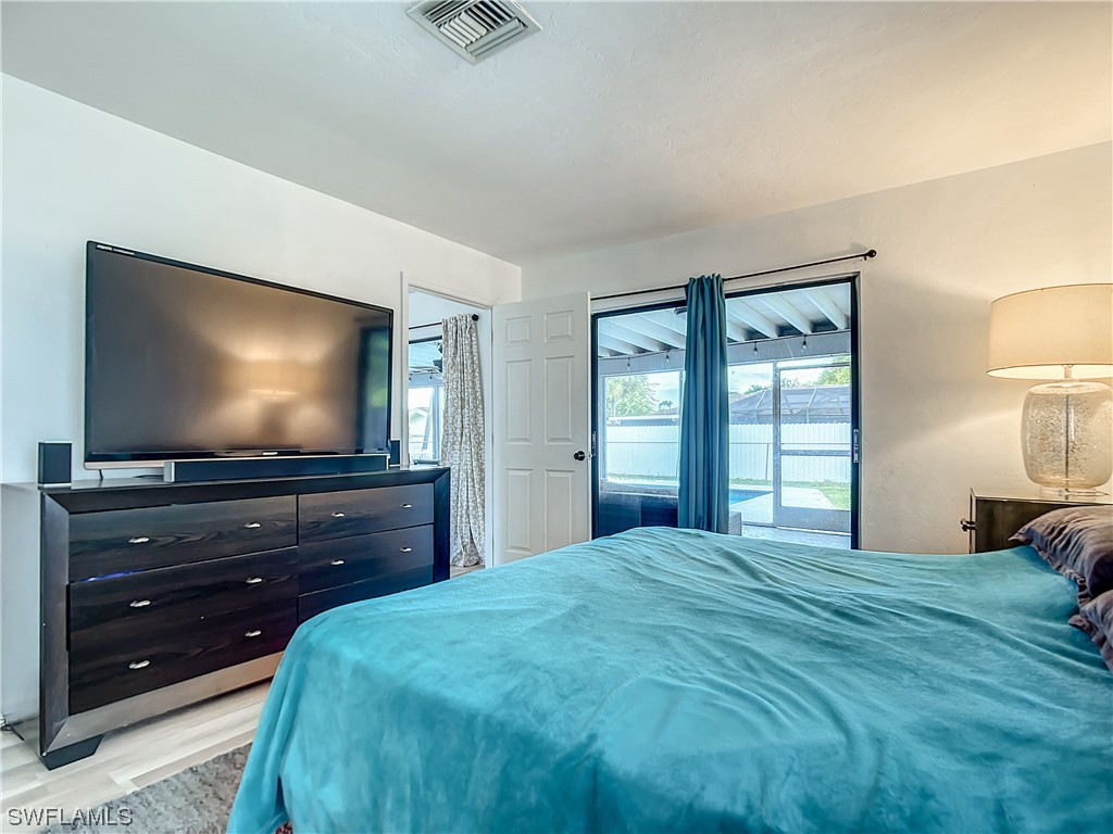 2437 42nd Terrace Southwest Naples, FL 34116 - Photo 20 of 34 a bedroom with a bed and a flat screen tv