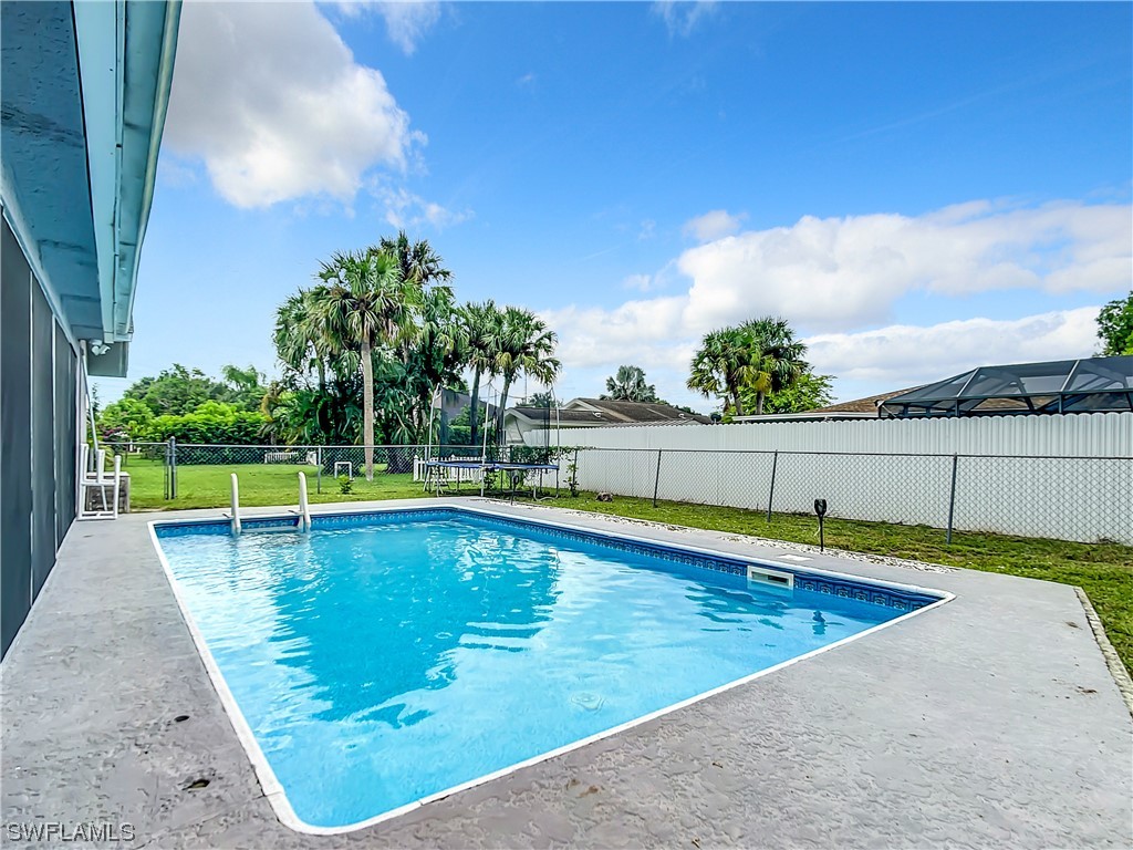 2437 42nd Terrace Southwest Naples, FL 34116 - Photo 30 of 34 a view of a swimming pool with an outdoor seating and a garden