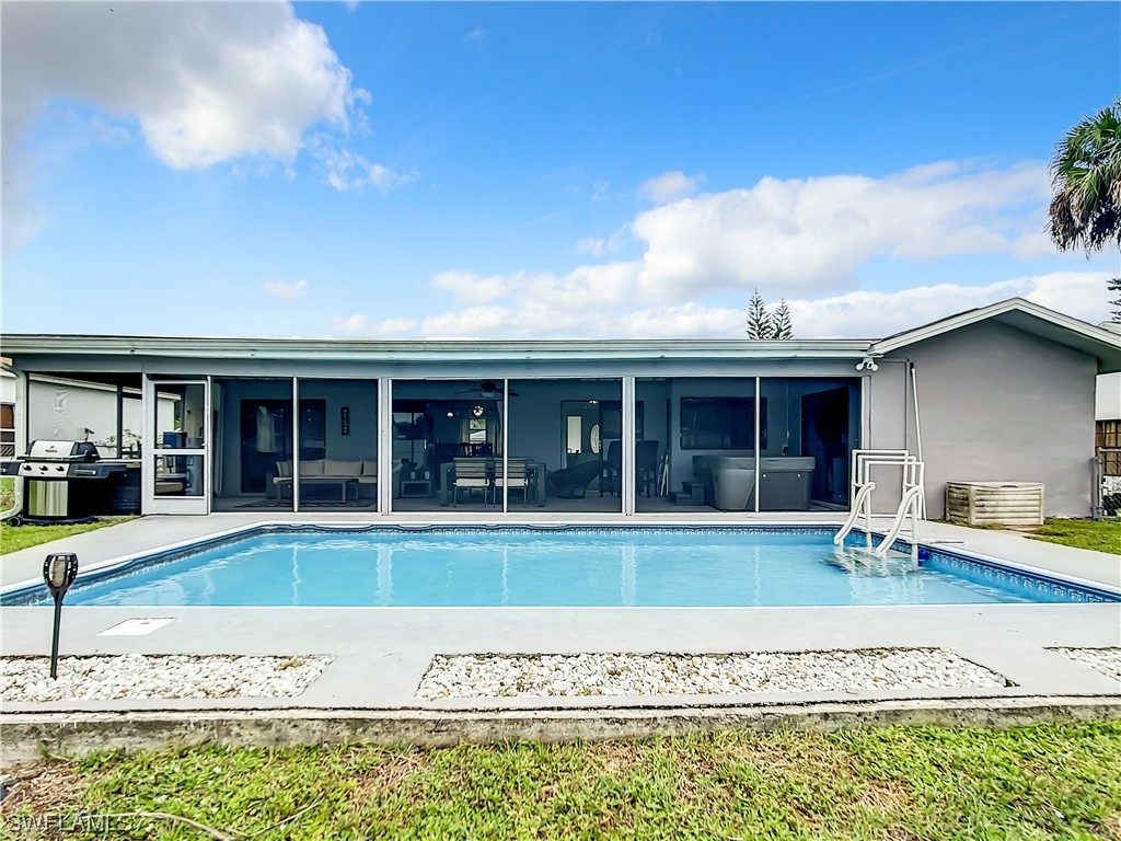 2437 42nd Terrace Southwest Naples, FL 34116 - Photo 31 of 34 a view of a house with a swimming pool and a yard