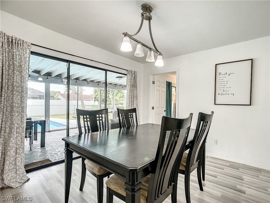 2437 42nd Terrace Southwest Naples, FL 34116 - Photo 8 of 34 a view of a dining room with furniture window and wooden floor