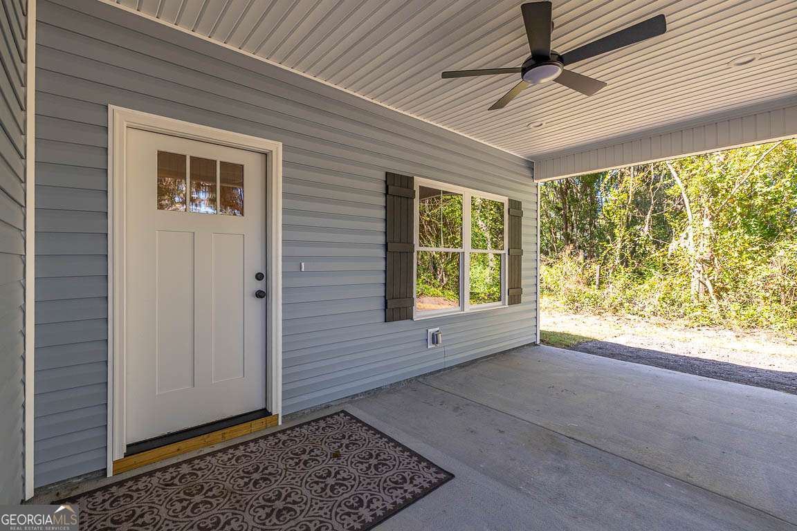 505 Madison Street Darien, GA 31305 - Photo 2 of 18 a view of an empty room with a window and wooden floor