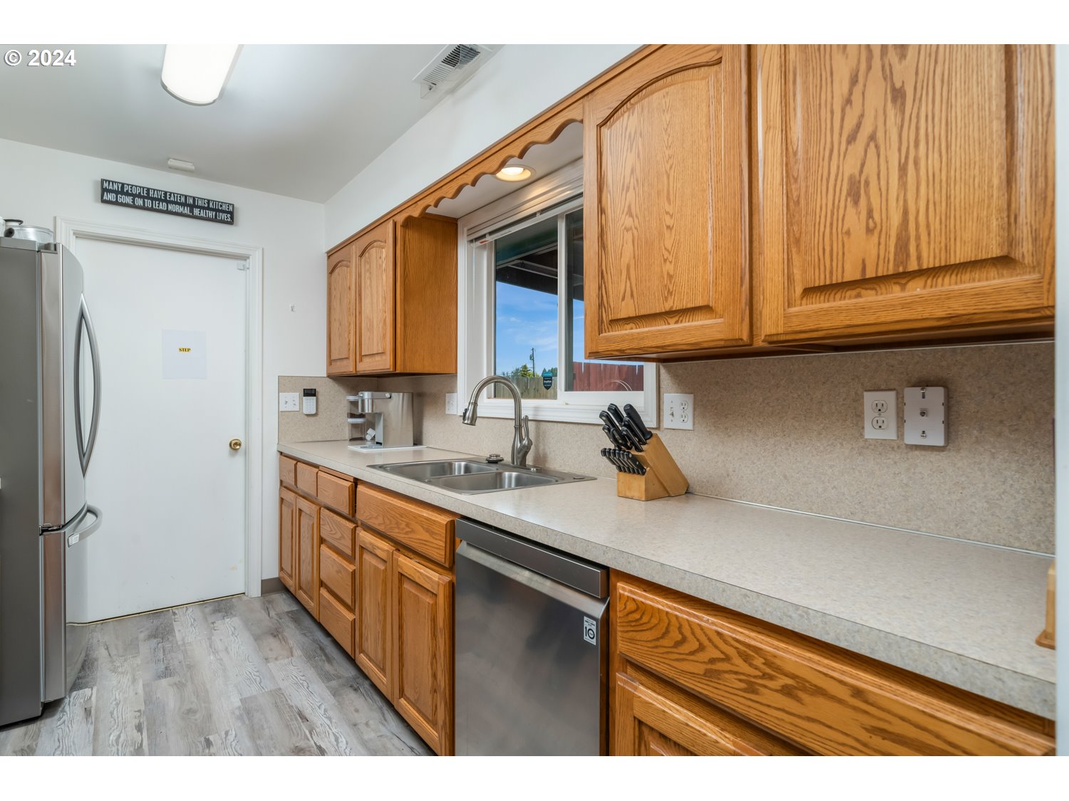 3217 Maple Street Longview, WA 98632 - Photo 15 of 32 a kitchen with stainless steel appliances granite countertop a sink dishwasher stove and refrigerator with wooden floor