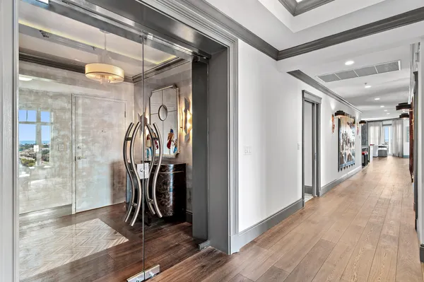 a view of a hallway with wooden floors and closet