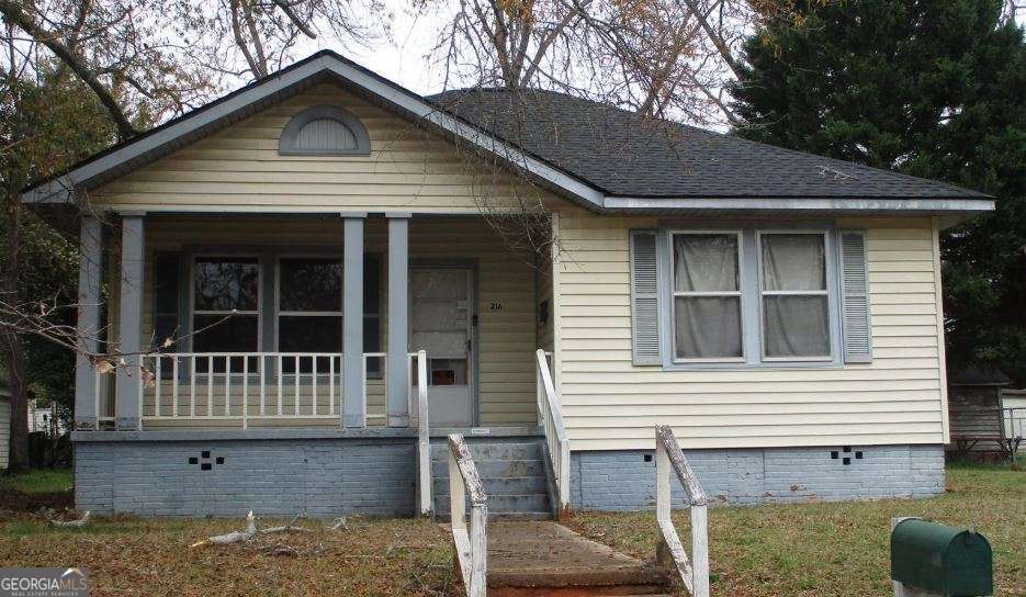 216 4th Avenue Southeast Thomaston, GA 30286 - Photo 6 of 7 a view of small white house with a small yard and large tree
