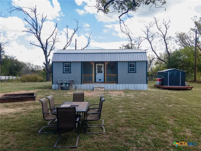 a view of a house with backyard and a sitting area