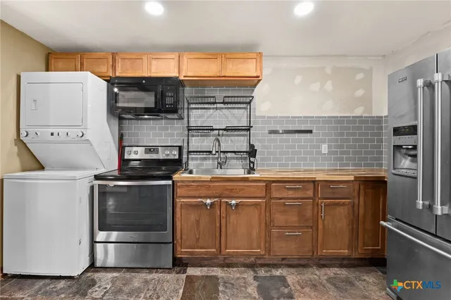 a kitchen with stainless steel appliances granite countertop a stove and a refrigerator