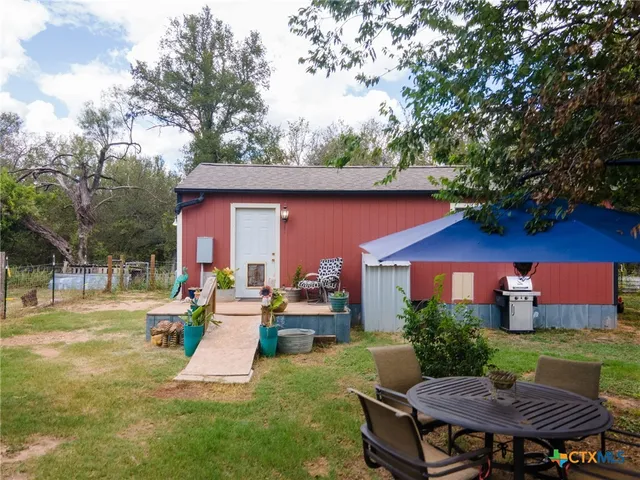 a view of a patio with couches and table and chairs and potted plants