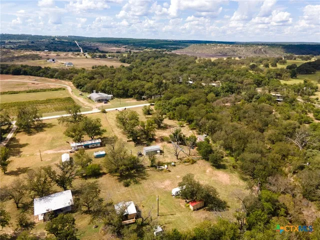 an aerial view of a house with a yard and lake view