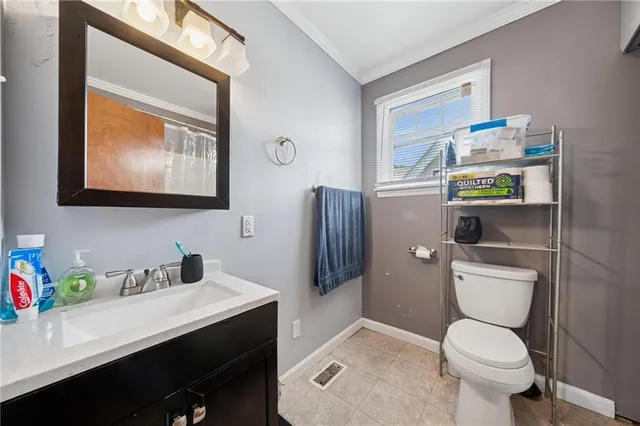 a bathroom with a toilet a sink and mirror