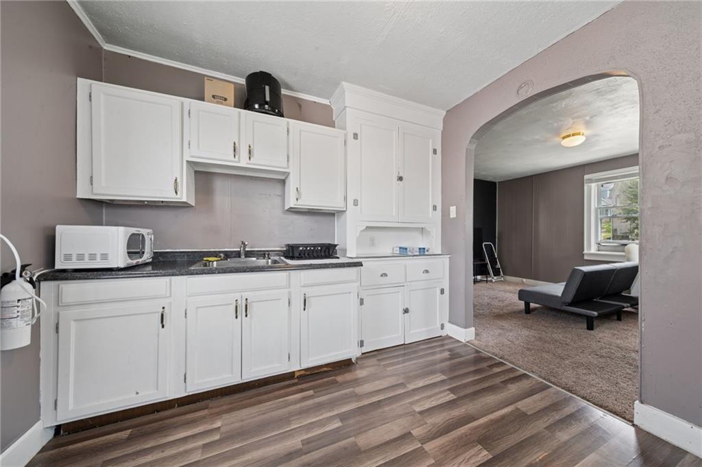 715 1/2 Armstrong, Unit 1/2 Apollo, PA 15613 - Photo 9 of 20 a large white kitchen with granite countertop a sink dishwasher a stove and a refrigerator with wooden floor