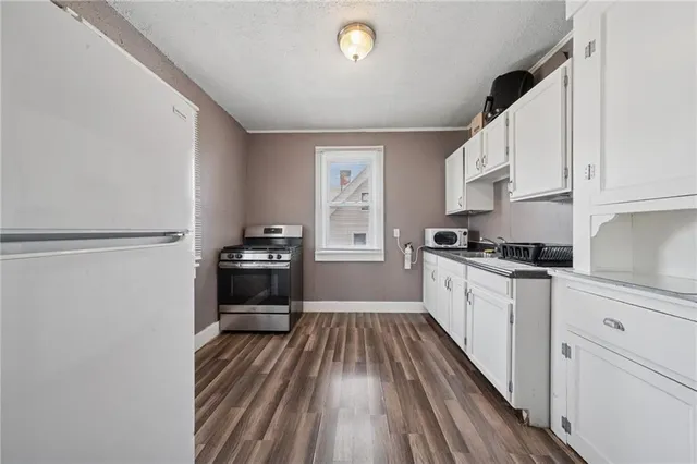 a kitchen with a refrigerator and white cabinets
