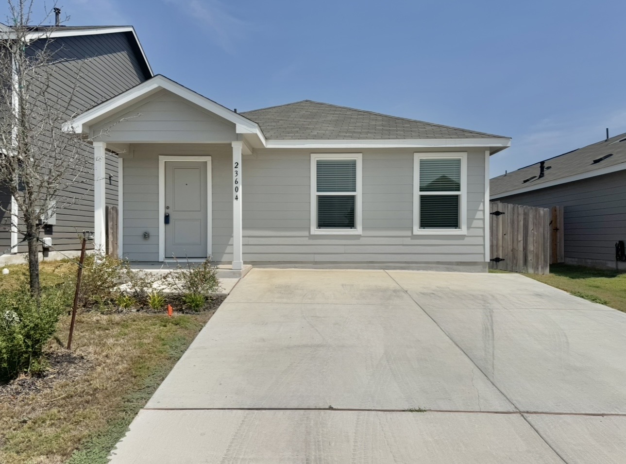 Clean lines and a concrete driveway define this modern single-story residence with a covered porch.