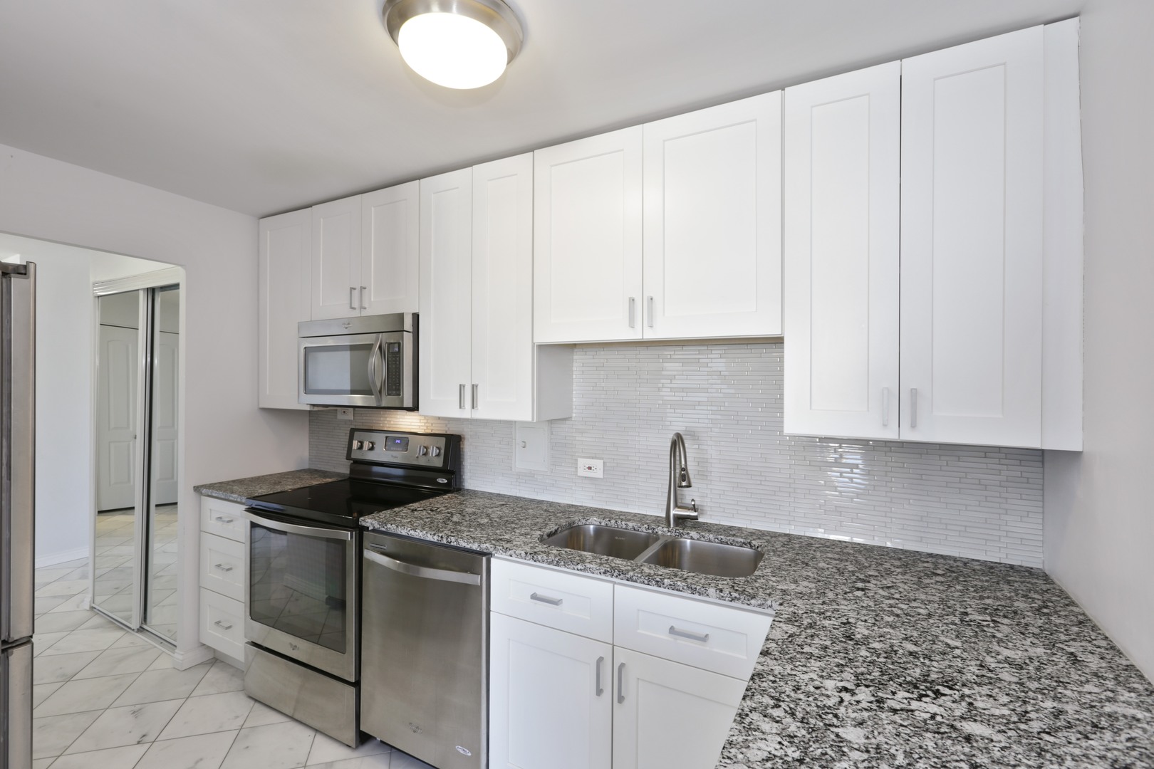 5701 North Sheridan Road, Unit 22H Chicago, IL 60660 - Photo 3 of 10 a kitchen with granite countertop a sink stove and refrigerator