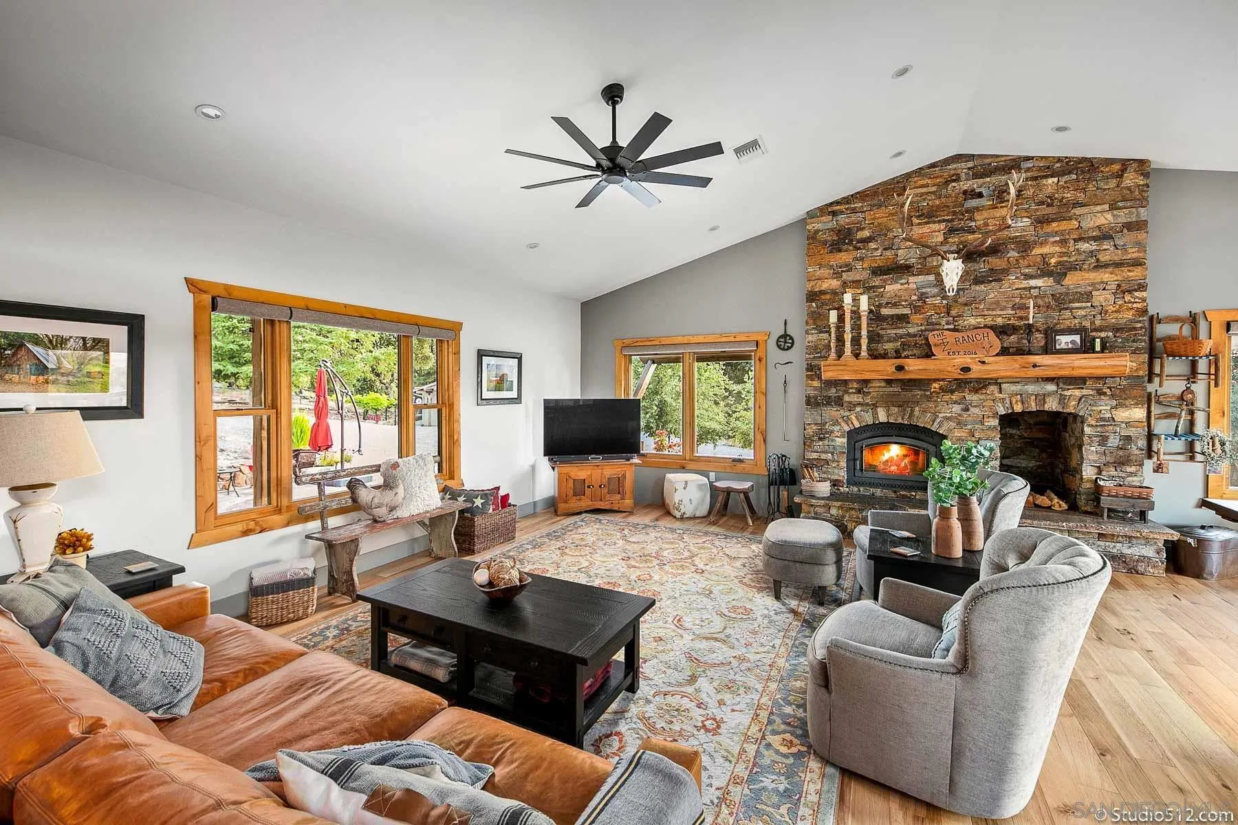 3208 Eagle Peak Road Julian, CA 92036 - Photo 24 of 65 a living room with furniture a fireplace and a large window